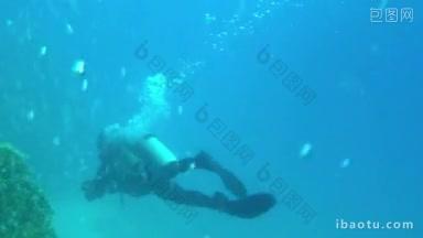自由潜水员带着潜水器和<strong>相机</strong>在水下靠近珊瑚礁的水下<strong>拍摄</strong>
